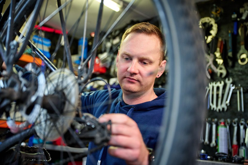 Man fixing a bike at the Cycle Hub on Cambridge Science Park